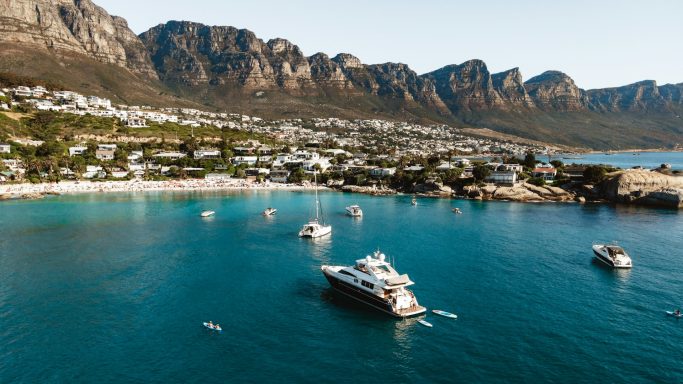 Blick auf eine ruhige Bucht mit Yachten und umliegenden Bergen.